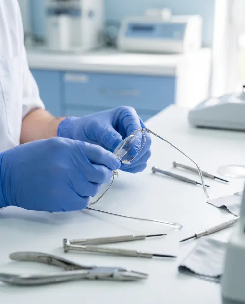 Óptico ajustando unas gafas en el taller con herramientas de precisión
